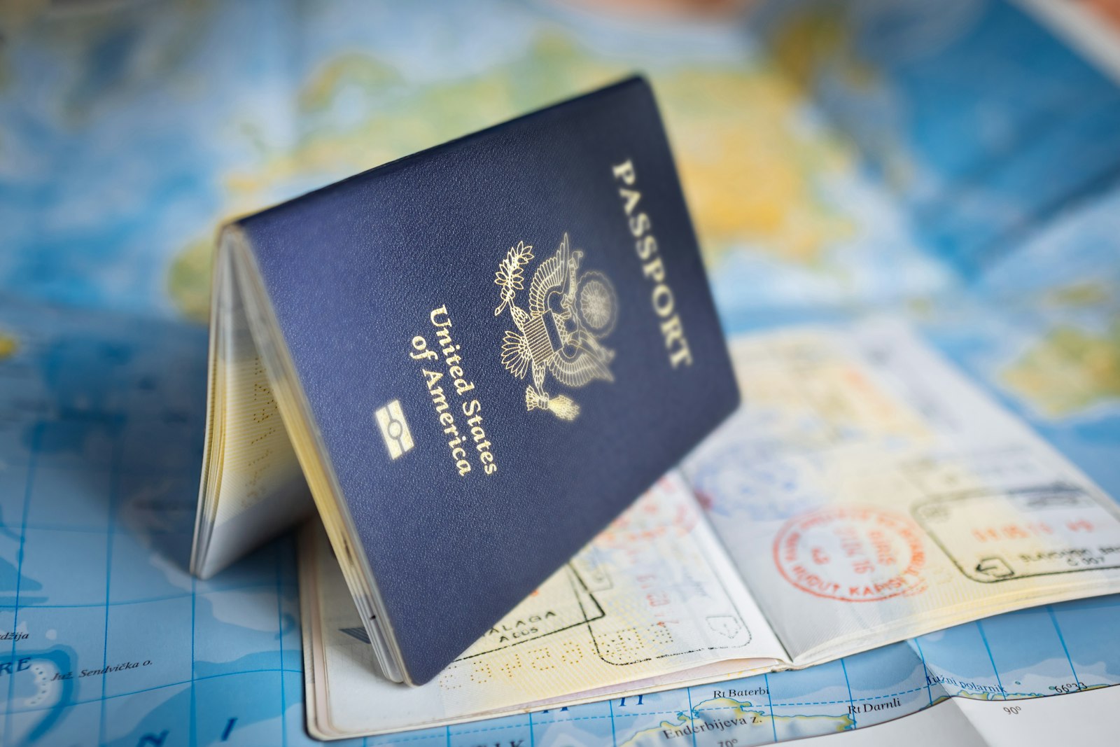 USCIS consular processing pivot 2026 — US passport with visa stamps