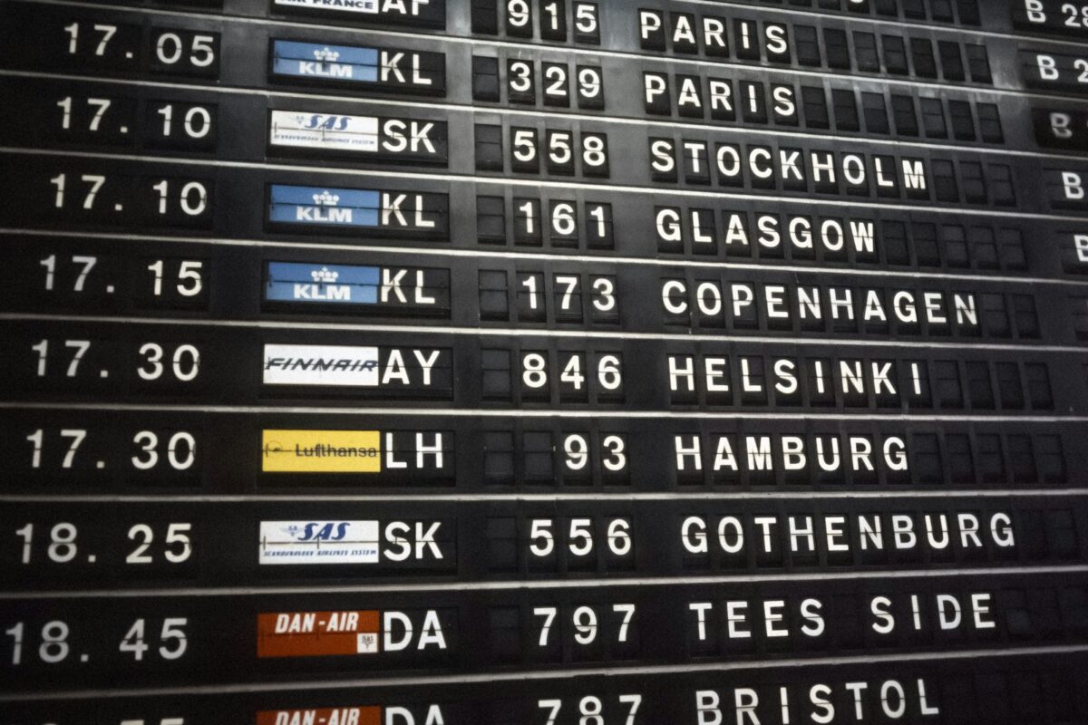 Work visa processing times traveller reading an airport departures board