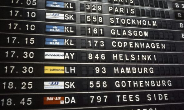 Work visa processing times traveller reading an airport departures board