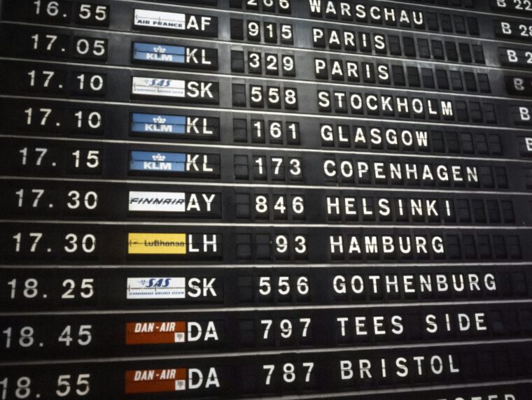 Work visa processing times traveller reading an airport departures board